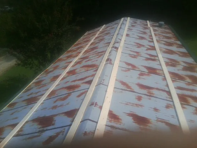 Rusted metal roof panels with new wood purlins before replacement — Storm Damage Roof Repair in Lometa by Roofing Brothers
